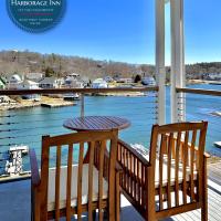 a table and chairs on a porch with a view of the water at Harborage Inn on the Oceanfront, Boothbay Harbor