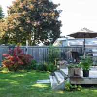 a backyard with an umbrella and some plants at The Cobourg Creek Cottage