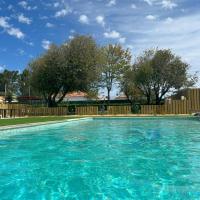 a large blue swimming pool with a wooden fence at Quinta da Boavista, Vila Nova de Milfontes