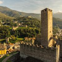a castle tower with a city in the background at Hotel Gamper, Bellinzona