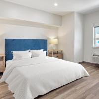 a white bedroom with a large bed and a window at Seaport Suites, Wildwood