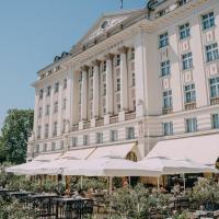 a building with tables and umbrellas in front of it at Esplanade Zagreb Hotel