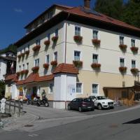 a large white building with cars parked in front of it at Hotel Kirchenwirt, Bad Kleinkirchheim