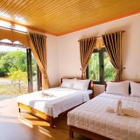 a bedroom with two beds and a large window at Thuy Tien Ecolodge, Cat Tien