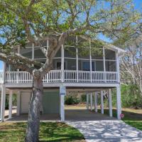 a house with a wrap around porch with a tree at The Holland House, Kure Beach