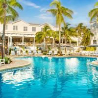 a swimming pool with chairs and palm trees in a resort at Margaritaville Beach House Key West