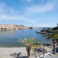 a view of a river with palm trees and a castle at Hôtel Triton, Collioure