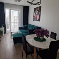 a living room with a table and a green couch at Apartamentai Ragaines g., Klaipėda