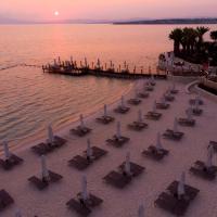 a group of tables and chairs on a beach near the water at Reges, a Luxury Collection Resort & Spa, Cesme