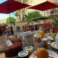 a table with breakfast food on a table with umbrellas at Le Petit Prince, Sainte-Maxime