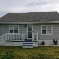 a small house with a white porch and a yard at Kure Beach Cottage-Fully Updated--1 block to beach---Pets welcome
