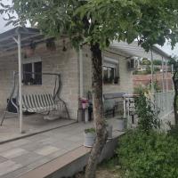 a porch of a house with a bench and a tree at Stone house next to Cluj-Napoca, Dezmir