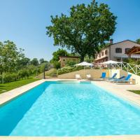 a swimming pool with blue chairs and a house at Casa Il Monte, Cartoceto