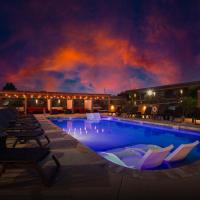 a swimming pool with lounge chairs and a building with a fire at GreenTree Inn Sedona