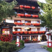 a hotel with flowers in front of a building at Landhaus Klausnerhof Hotel Garni, Seefeld in Tirol