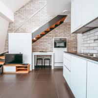 a kitchen with white cabinets and a sink and a staircase at WakeUp Esch-City, Esch-sur-Alzette