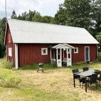 Red little cottage located in the forest and next to a small lake