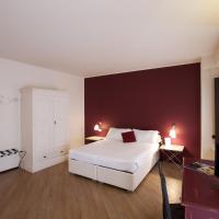 a bedroom with a white bed and a red wall at Hotel Leon D'Oro, Mantova