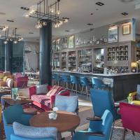a restaurant with colorful chairs and a bar at Canopy by Hilton Zagreb City Centre