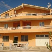 a large orange house with a balcony at Apartments Vidović, Sveti Petar
