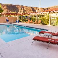 a swimming pool with two red lounge chairs next to it at Hotel Moab Downtown