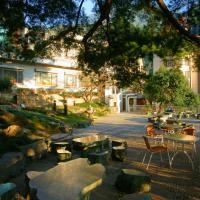 a courtyard with tables and chairs and a building at Utopia Holiday Hotel, Heping