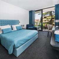 a bedroom with a blue bed and a balcony at Hotel Arupinum, Rovinj