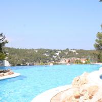 a pool at a resort with blue water at Apartamentos del Rey, Portinatx
