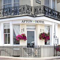 a hotel with a balcony and flowers in front of it at Afton Hotel, Eastbourne