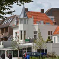 a white building with a pointed turret on a city street at Hotel Restaurant Piccard, Vlissingen