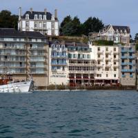 a boat in the water in front of buildings at Hôtel-Restaurant Printania, Dinard