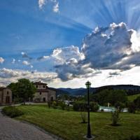 a cloudy sky with a building and a street light at Il Cardo Resort, Anghiari