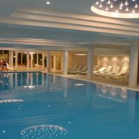 a large swimming pool in a hotel with people standing around it at Hotel Ambasador Chojny, Łódź
