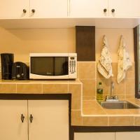 a kitchen with a microwave and a sink at M&A Riverside Beach Bungalows, Chol