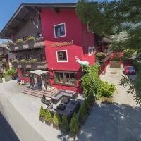 a red building with a restaurant on a street at Hotel Gamshof, Kitzbühel
