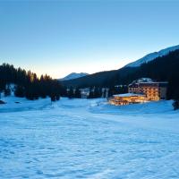 a building in the middle of a snow covered field at TH Madonna di Campiglio | Golf Hotel
