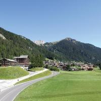 a winding road in a valley with mountains in the background at Hotel il Caminetto Sport, Canazei