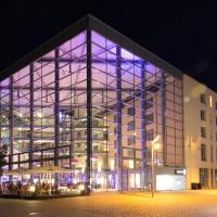 a large building with a large glass facade at night at Dorint Hotel am Dom Erfurt
