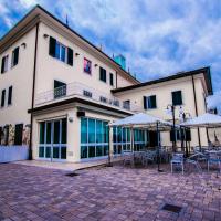 a building with tables and umbrellas in front of it at Hotel Butterfly - We Suite, Torre del Lago Puccini