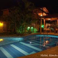 a swimming pool in a yard at night at Hotel Nantu Hostería, Puerto López