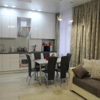a kitchen and living room with a table and a couch at City Life Apartments on Pushkinskaya, Brest