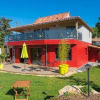a red house with a deck with tables and umbrellas at Homgaïa chambres d'hôtes, Clisson