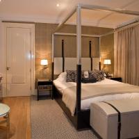 a bedroom with a canopy bed and a table at Langtons Hotel Kilkenny