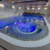 a large pool with a blue tub in a building at Hotel Orion, Abertamy