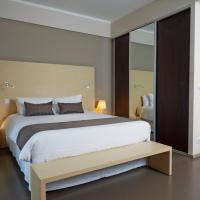 a bedroom with a large bed and a large mirror at Hôtel du Centre, Noumea
