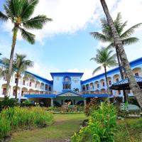 a large building with palm trees in front of it at Airai Water Paradise Hotel & Spa, Koror