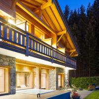 a large house with a deck and a patio at Hotel et Spa Le Delta, Le Grand-Bornand