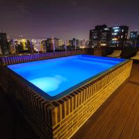 a swimming pool on the roof of a building at night at Hotel Alex Caracas