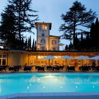 a swimming pool in front of a building with a clock tower at Relais Cappuccina, San Gimignano