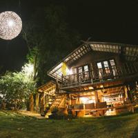 a large wooden house at night with a disco ball at Rice Barn And Rooms, Hang Dong